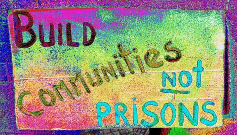 Artwork that says 'Build communities not prisons'.