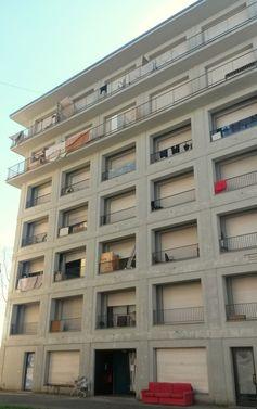 An abandoned brown building with items on balconies.