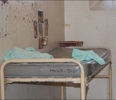 Dirty prison bed and walls.