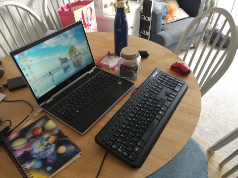 Circular dining table with laptop and keyboard