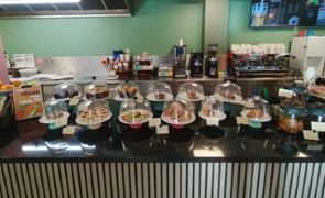 a cafe counter with a selection of cakes under cloches