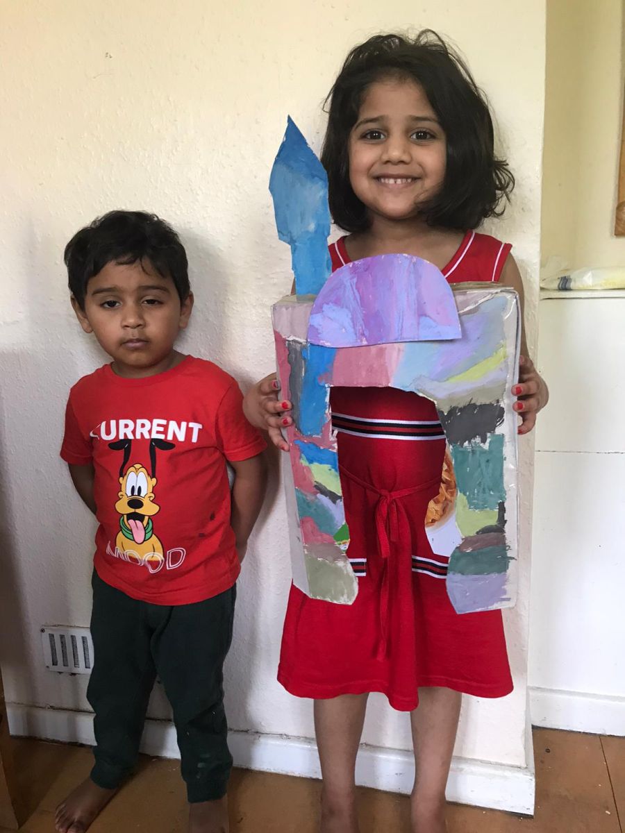 Two beautiful, happy children showing off their work, one boy and one girl