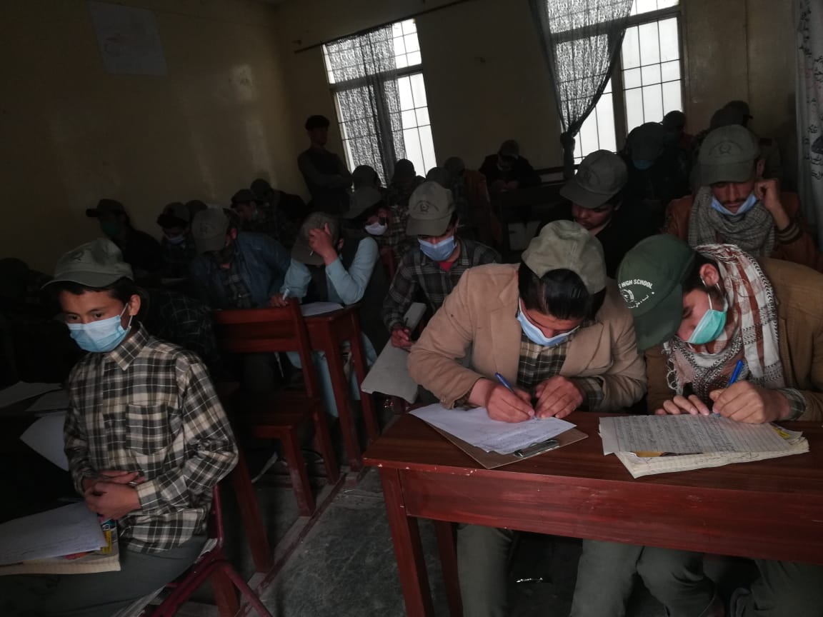 Older school boys work assiduously in cramped conditions