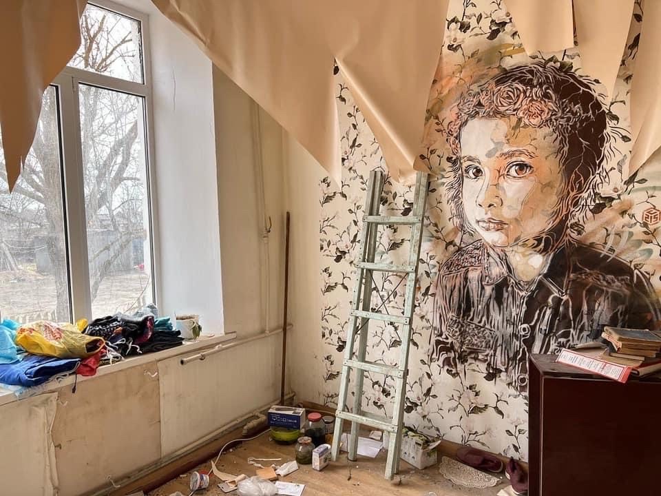 portrait of a girl on the wall a flat destroyed by Russian rockets