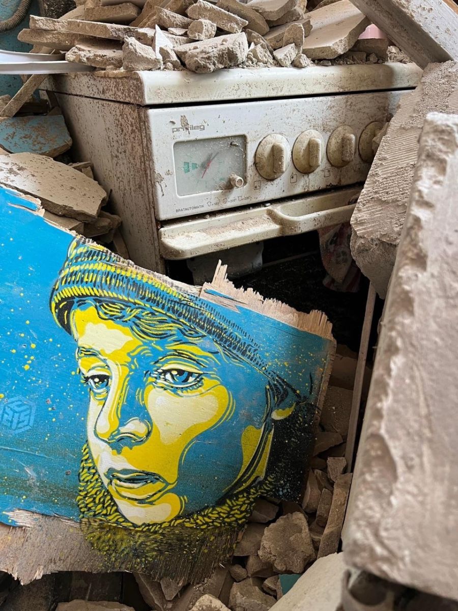 painting children faces on a building totally destroyed by Russian bombs