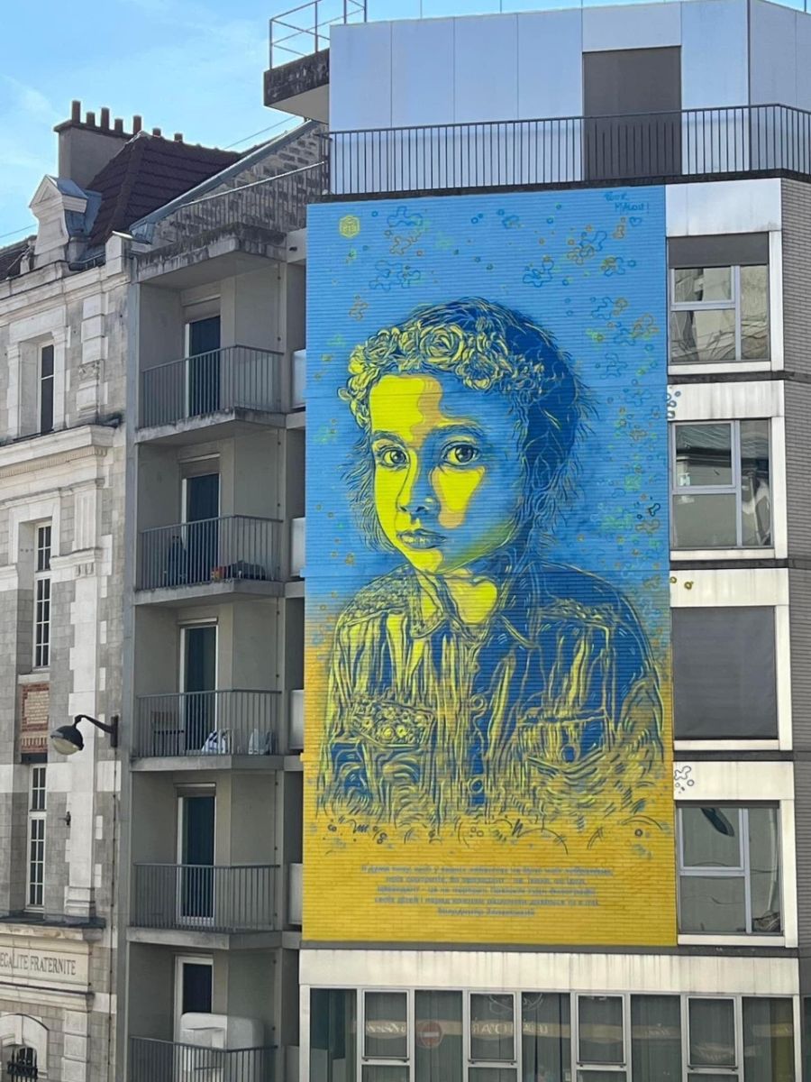 painting children faces on a building totally destroyed by Russian bombs