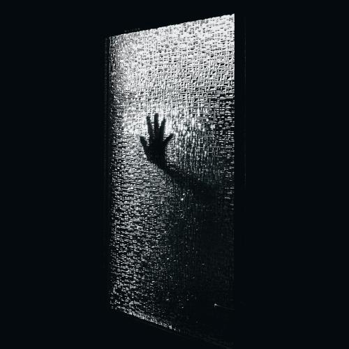 hand on a glass of a black door