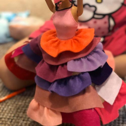 Cindy wears a colourful dress with multiple layers