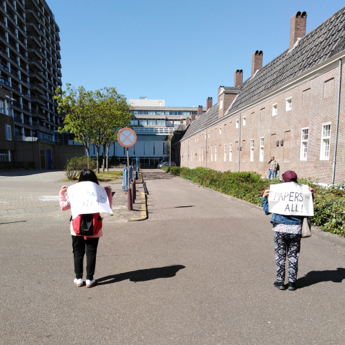 two women walk along the pavement of an empty Hague street