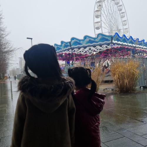 Two little girls look at the rides with excitement
