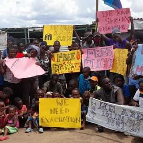 Regugees holding support placards