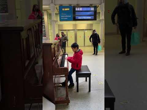 A hongkong boy playing piano at Pancras train station