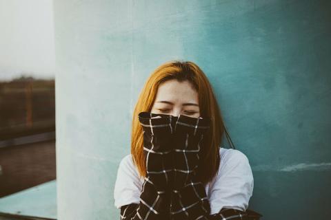 women with hands coving half of her face