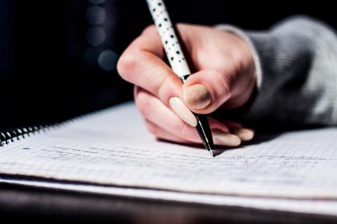 a hand writing on a paper