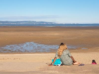 women sitting on Welsh beach