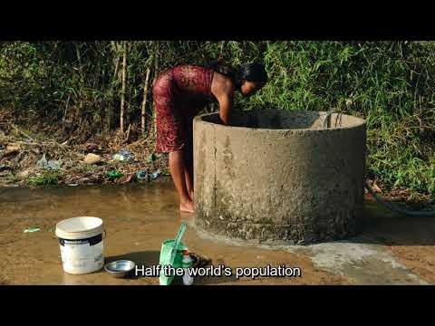 red dressed women lean over a well