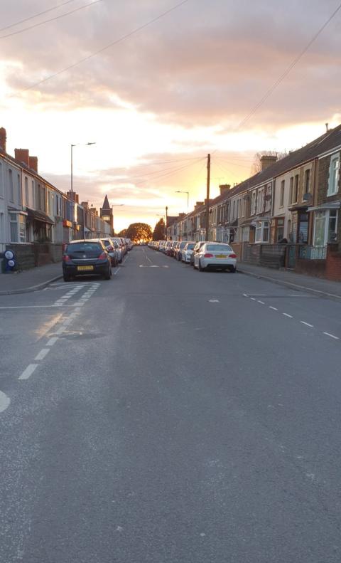 A very quiet street is shown with a beautiful sky behind it