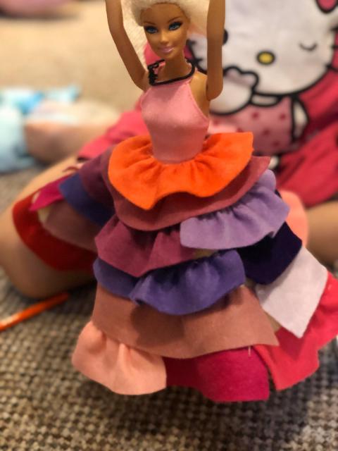 Cindy wears a colourful dress with multiple layers