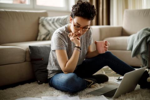 Female sitting on floor studying with laptop