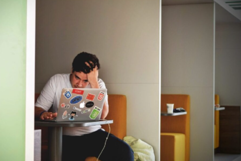Student looking at computer anxiously