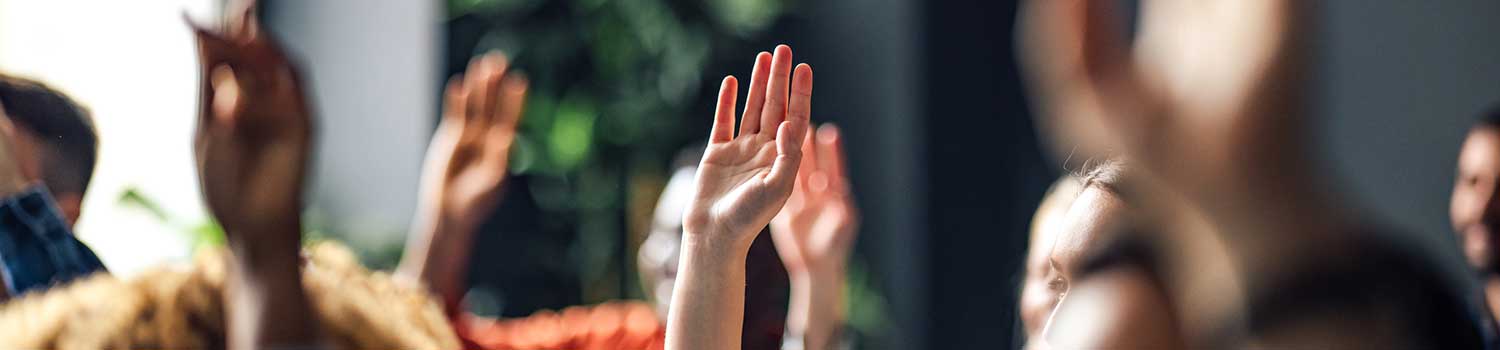 a close up on a number of raised hands to ask questions