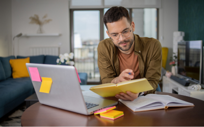 Man studying at laptop with notes