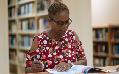 a woman in a library readying a book