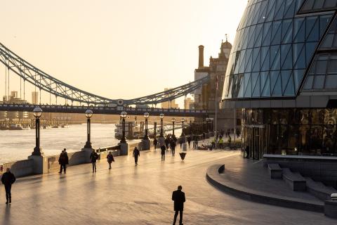 People walking by a river in a city