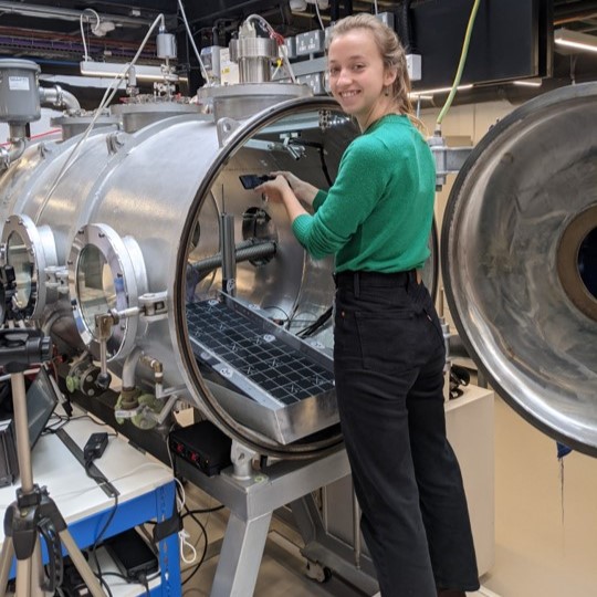 Image of Lonneke Roelofs standing next to George Chamber loading her experiments