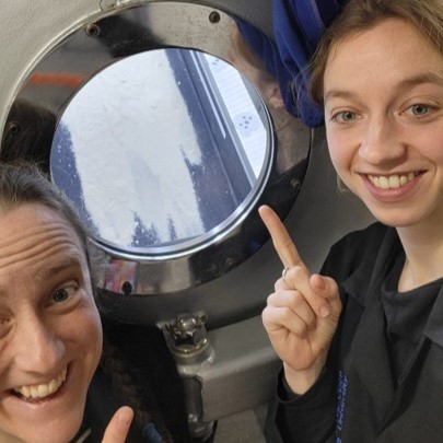 Image of Lonneke Roelofs and Susan Conway posed by the George Chamber viewport looking at their experiments