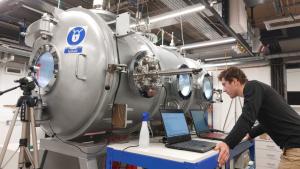 Researcher standing next to Mars Chamber monitoring an experiment