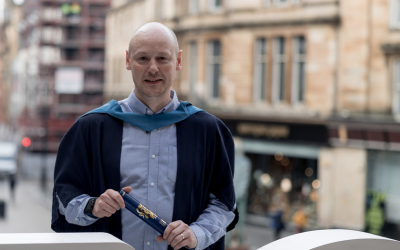 Craig Stevely wearing OU graduation robes