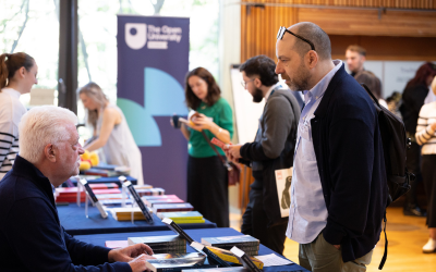 Event attendees browsing books and in discussion with stallholders