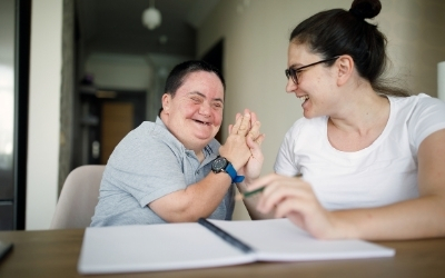 Two people seated at a table and smiling