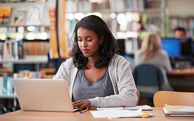 A seated female student using a laptop