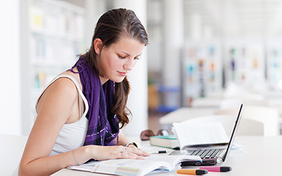 Female studying, with books and laptop