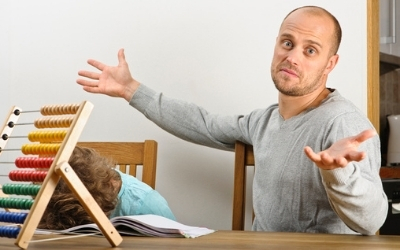 Man struggling to help boy with maths homework