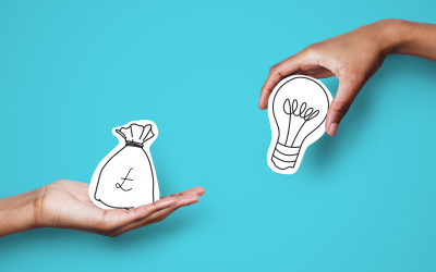 A hand holding a drawing of a money bag and another holding a lightbulb