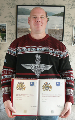 Veteran Steven Wilson, holding his Open University certificates.