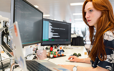 A woman at a desk looking at a computer screen