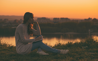 Woman writing at sunset