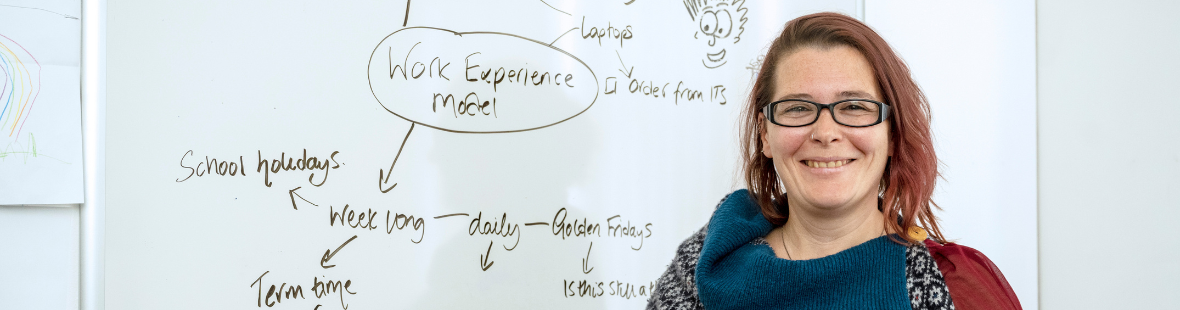 Maria Bell from Mesomorphic standing in front of a whiteboard with ideas about work experience on it