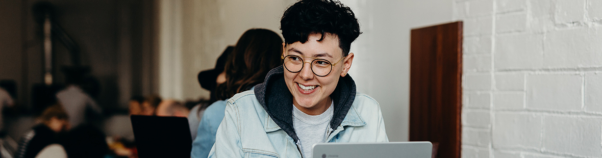 A smiling laptop user in a cafe