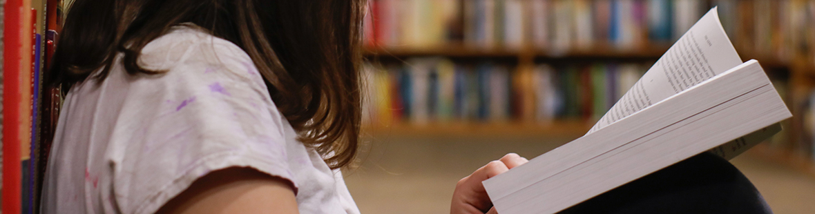 A close-up shot of a person reading a book