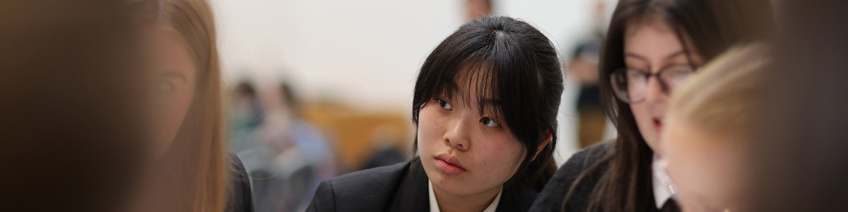 A high school student listening in a group.