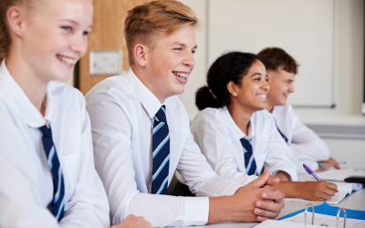 High school student with braces, smiling in class