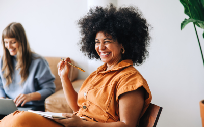 Two seated smiling women, in a meeting. Picture by JLco - Julia Amaral.