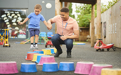 Nursery worker with child in playground