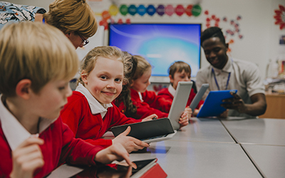 Pupils seated in a classroom, looking at iPads 