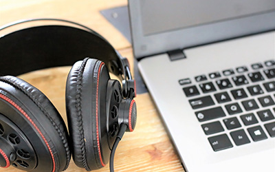 Headphones on a table next to laptop